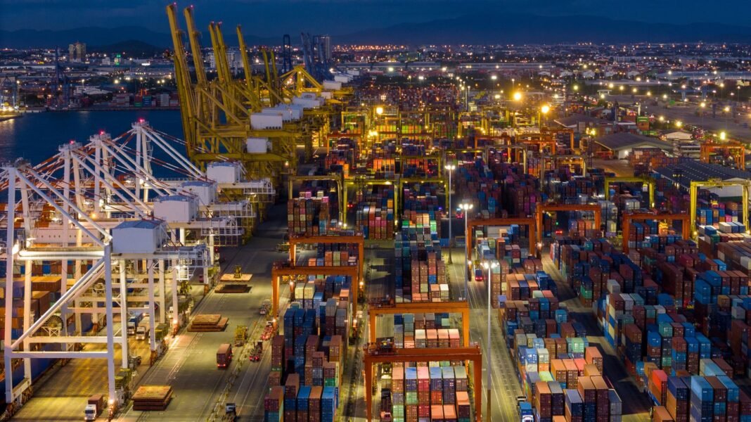 Factories faced weaker manufacturing demand, higher costs in July as Iran war grinds on Shipping containers at a port at night as manufacturing demand weakens amid supply chain disruption